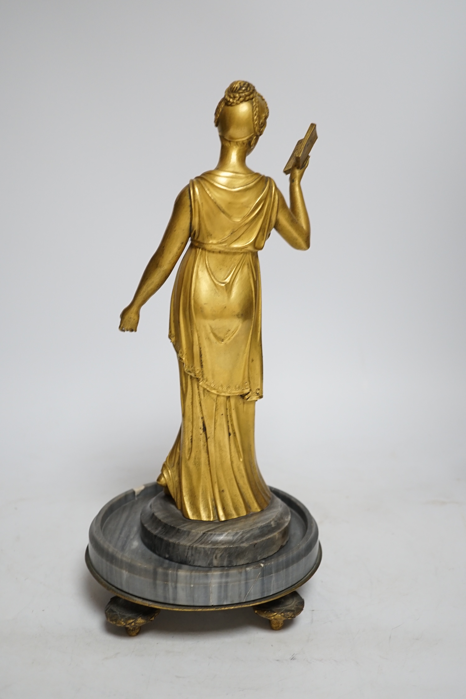 A 19th century French ormolu figure of a woman reading, on a two-piece grey marble base, 33cm high